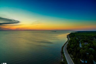 aerial photo of lake huron sunset and winding shoreline road