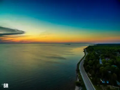 aerial photo of lake huron sunset and winding shoreline road